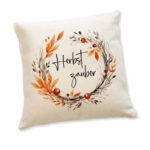 Leinenkissen Herbstzauber mit herbstlichem Kranz aus Blättern und Beeren – naturfarbene Kissenhülle mit Schriftzug Herbstzauber in schwarzer Schrift.